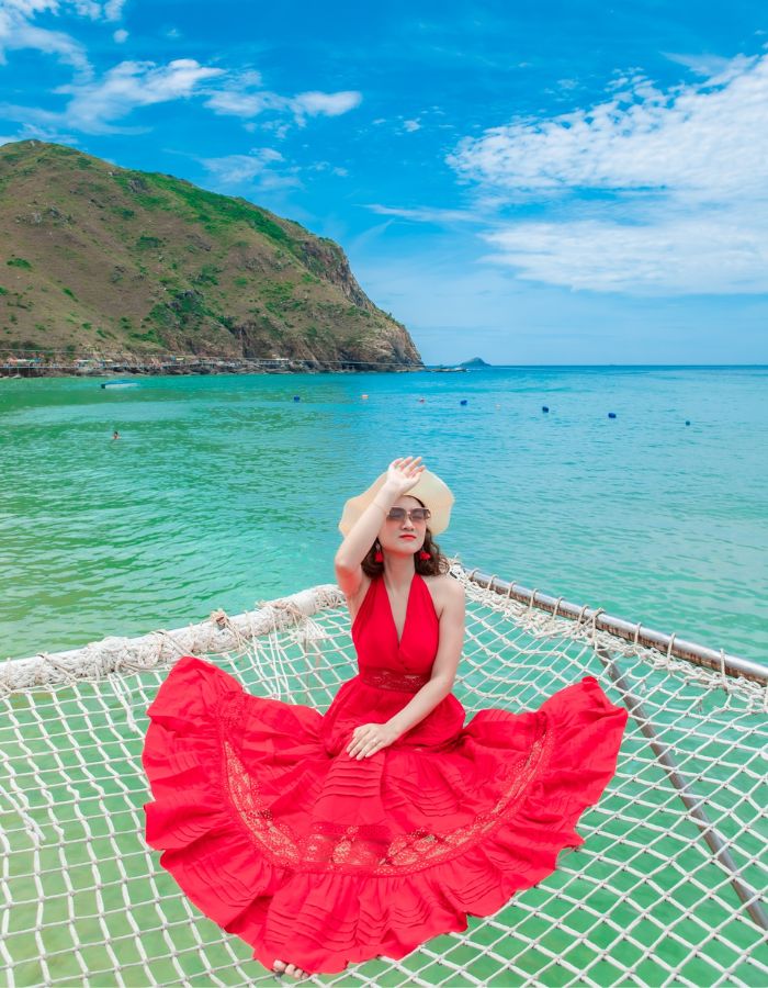 Girl-in-red-dress-poses-for-photo-with-Ky-Co-beach-in-the-background