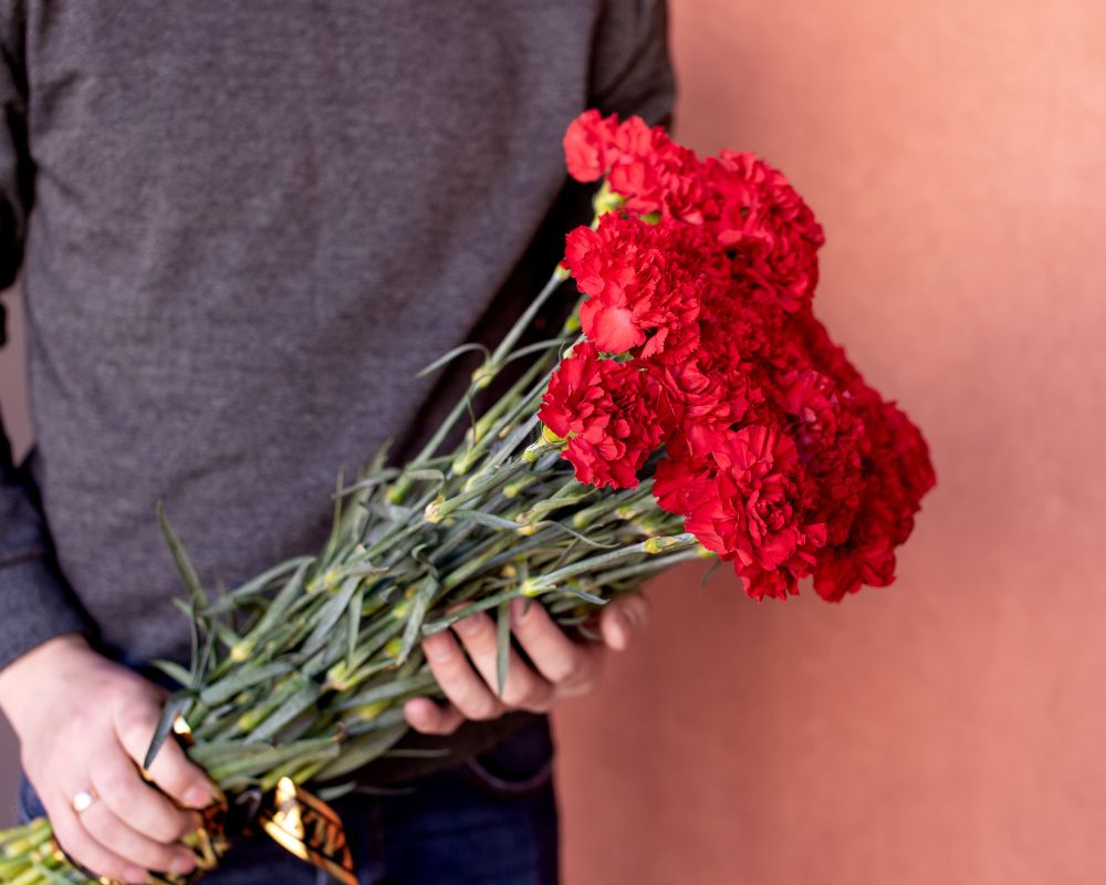 Red-carnations-in-the-hands-of-a-man