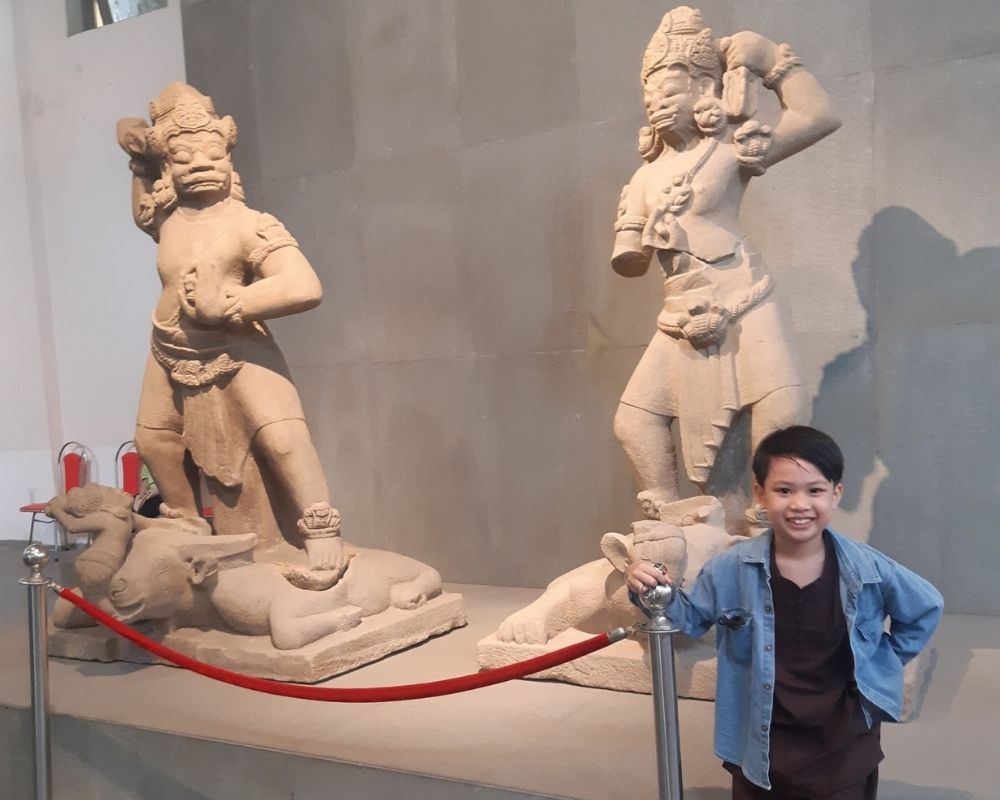 The-boy-takes-a-photo-with-two-gold-in-ancient-Cham-Kingdom